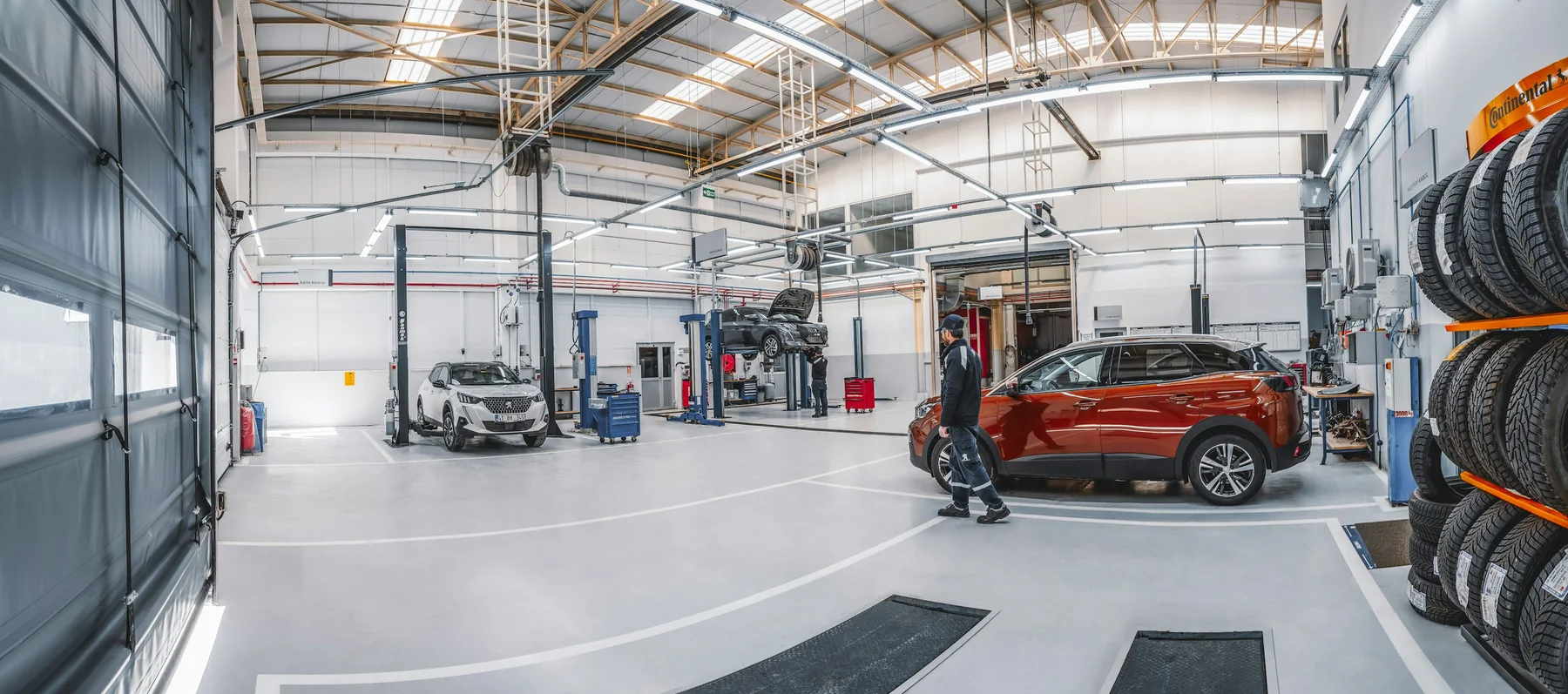 Helle Werkstatt mit Fahrzeugen und Serviceplätzen